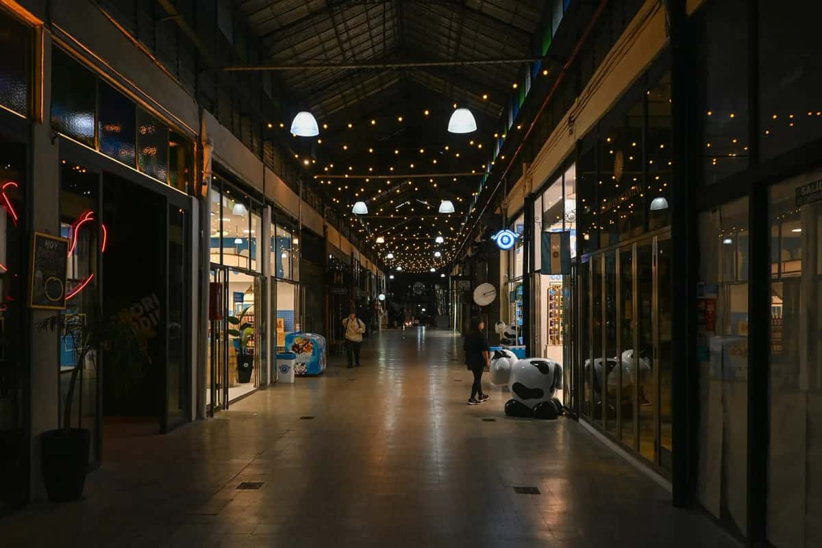 Galerie intérieure du marché de San Telmo à Buenos Aires, boutiques éclairées sous la charpente métallique